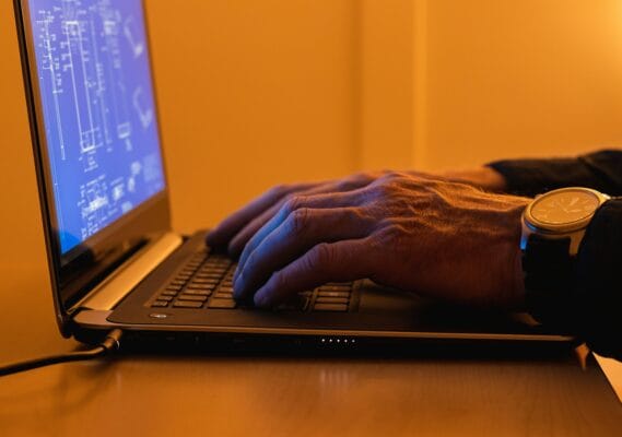 Mann tippt auf Laptop für CAD Anwendungen