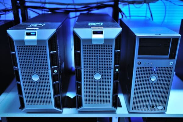Drei physische Servergehäuse nebeneinander in einem blau beleuchteten Serverraum