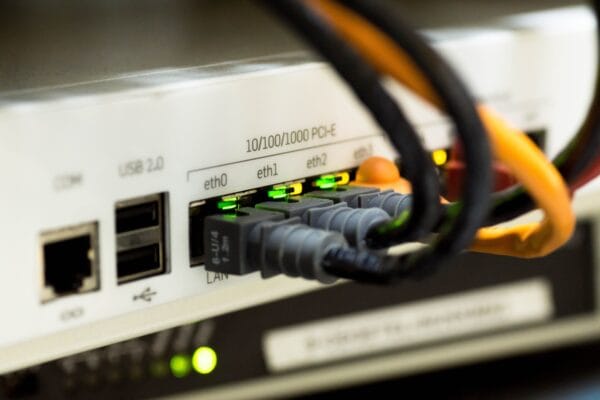 Nahaufnahme mehrerer Ethernet-Anschlüsse mit eingesteckten Netzwerkkabeln und aktiven Status-LEDs