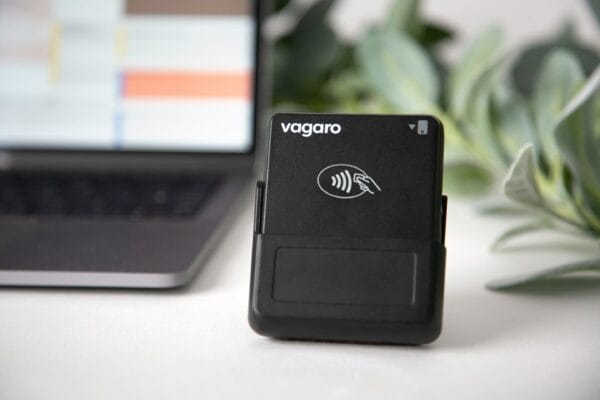 Kompakter RFID Reader mit Kontaktlos-Symbol vor einem Laptop am Arbeitsplatz