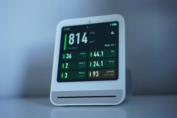Weißes Luftqualitätsmessgerät mit Display für CO₂, Temperatur, Luftfeuchtigkeit und Feinstaub.