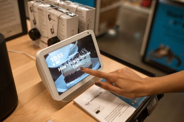 Eine Person berührt ein weißes Smart Display, auf dessen Bildschirm ein Brownie-Rezept angezeigt wird.